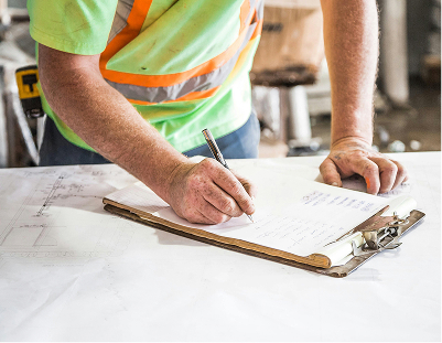 Construction worker writing on a clipboard